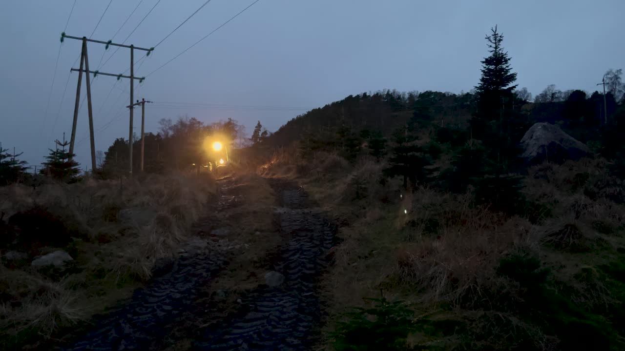 tractor agrícola moviéndose por el sendero en una puesta de sol después del trabajo de cosecha