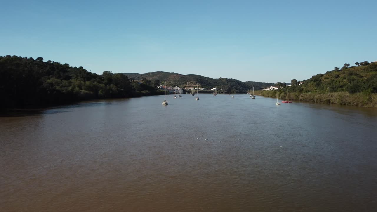 Slow motion over Guadiana River aerial view. Just arriving to Alcoutim (Algarve city - Portugal). Drone movement over the boats.