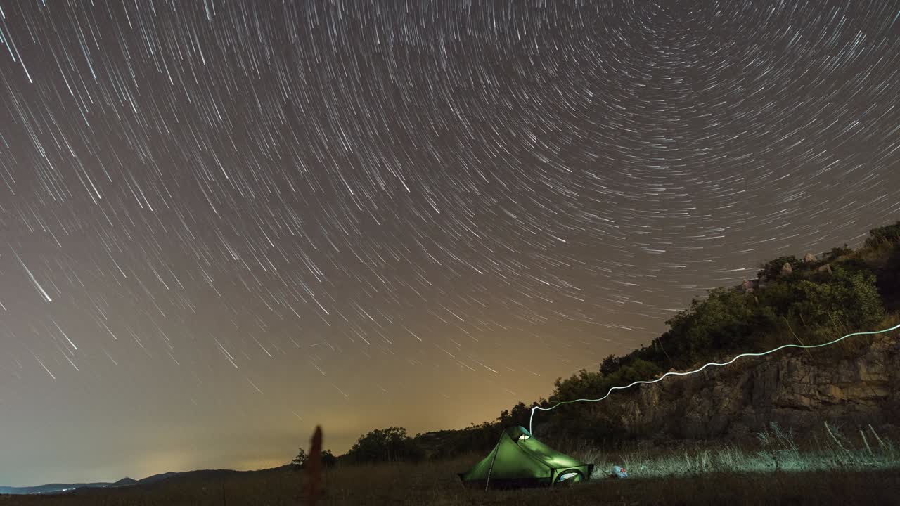 startrails con polaris en círculos sobre la tienda en el paisaje croata por la noche