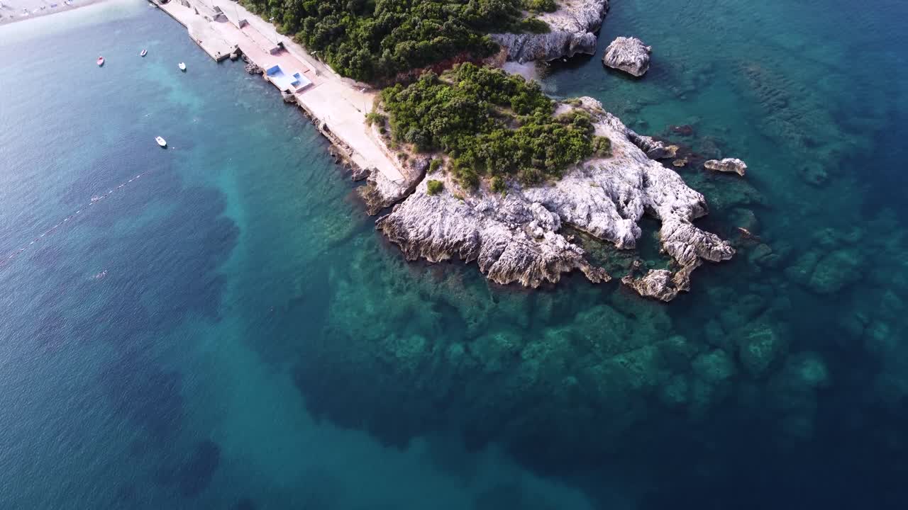 Piccola penisola rocciosa con acqua blu cristallina nel Mare Adriatico, vista aerea.