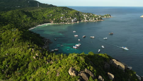 aerial view of shark bay koh tao thailand, south east asia famous spot for scuba diving class, boat moored at bay scenic seascape and pure unpolluted nature with warm sunset light