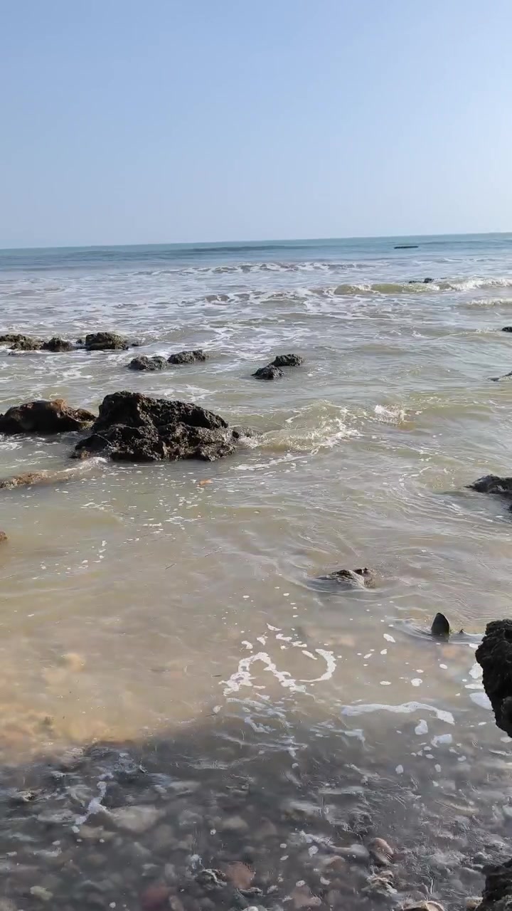 Onde delicate dell'oceano che si infrangono su litorale roccioso
