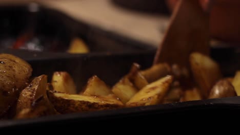 crunchy oily potato wedges being tossed in a container, closeup