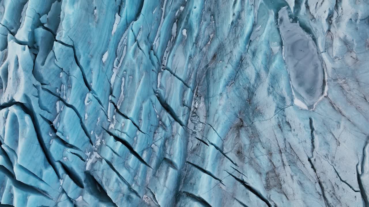 vista aérea de arriba sobre las formaciones de hielo de textura de un glaciar en islandia, al anochecer
