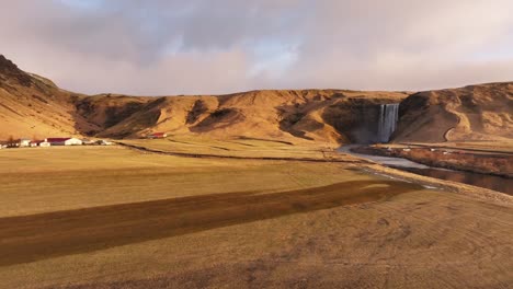 skógafoss waterfall, flowing skógá river, rugged terrain of skógar, iceland, aerial view