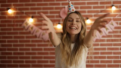 Portrait-of-woman-celebrating-birthday-looking-at-camera-positively-and-blowing-air-kiss