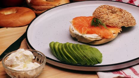 bagel sandwich brunch, lunch plate of a bagel with smoked salmon and cream cheese and ham, close up morning cafe menu.