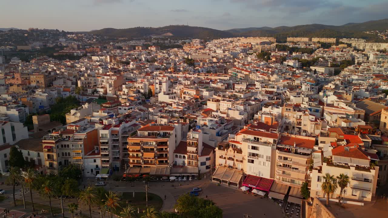 Luftfoto af kystbyen Sitges og kirken ved solnedgang.