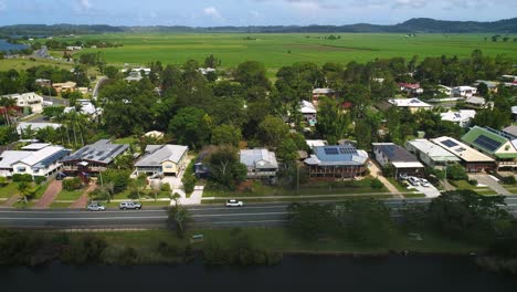 Aerial-view-over-Tumbulgum-with-farm-land-in-the-background,-along-the-Tweed-River,-Northern-New-South-Wales,-Australia