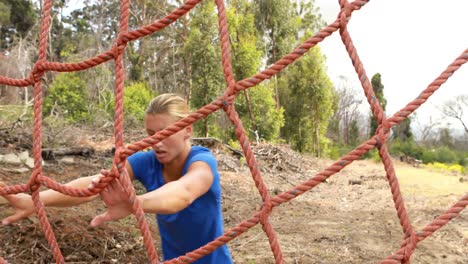 Fitte-Frau-Klettert-Während-Des-Hindernisparcours-Auf-Ein-Netz