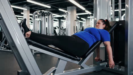 woman working out on leg press machine at gym