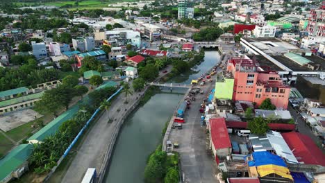 aerial dolly shot of a third-world country setting with calm river in between rural community town in virac, catanduanes during daytime