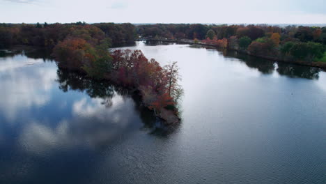 Aerial-of-a-peninsula-in-a-lake-at-Roger-Williams-Park-full-of-trees-in-autumn-colors