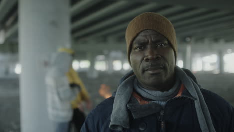 portrait of a man under a bridge with a fire
