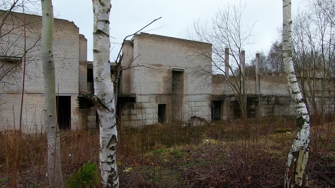 Abandoned White Brick Building Between Trees. Dolly In Slow Motion Shot