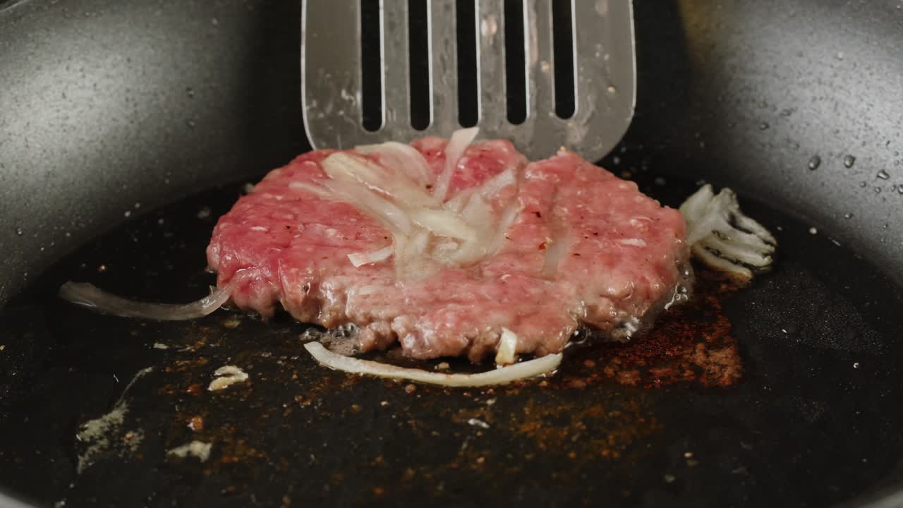 Cooking a hamburger patty in a pan
