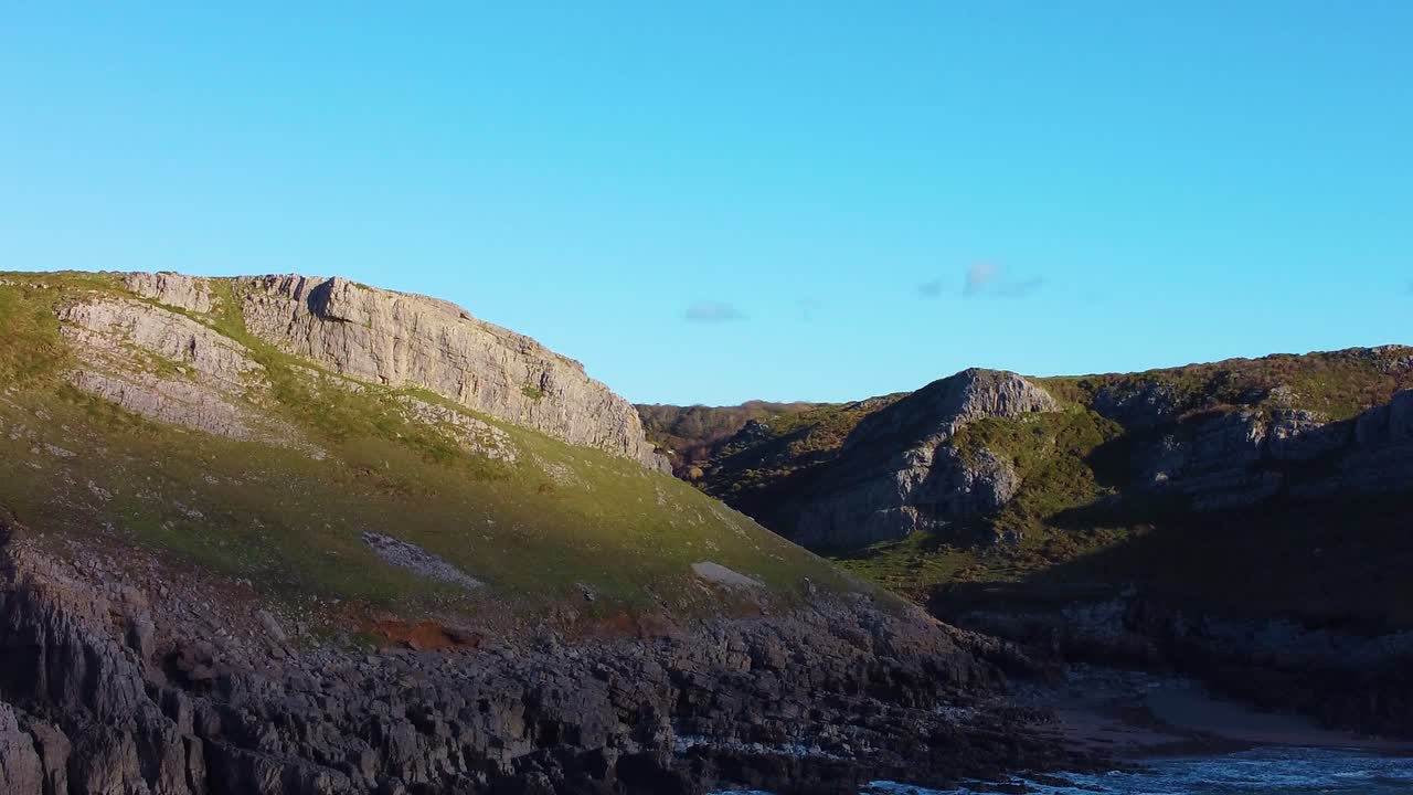 Amazing Aerial View of Sunlight Lighting Up Coastal Cliffs Over Mewslade Bay. Travel Nature Drone Clip. Beautiful Welsh Gower Peninsula Coast
