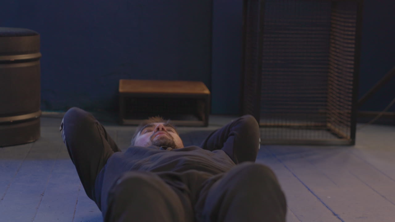 바닥에 누워서 복근 운동을 하는 지친 남자