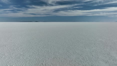 uyuni, bolivia - tourists friends running alone with freedom at the desertic salar de uyuni covered with water and salt in romantic slow motion