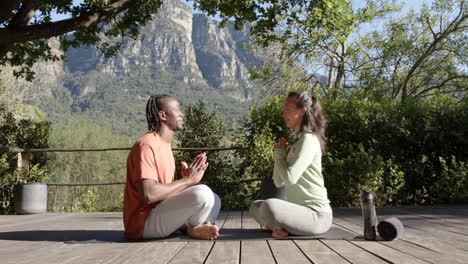 Feliz-Pareja-Diversa-Practicando-Meditación-De-Yoga-Sentada-En-La-Naturaleza-Soleada,-Espacio-Para-Copiar,-Cámara-Lenta