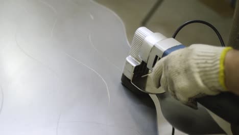 worker cutting metal sheet with power tools