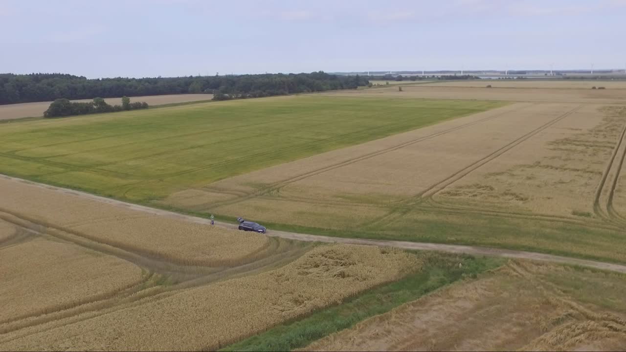 Aerial View of Harvested Wheat Fields and a Car