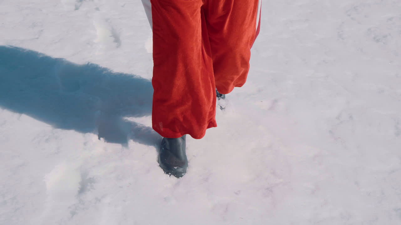 산타의 발이 눈 속을 걷고 있다