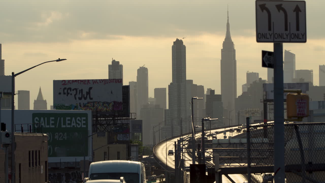 Empire State Building And Midtown Manhattan NYC Skyline With Traffic Moving On Long Island Expressway