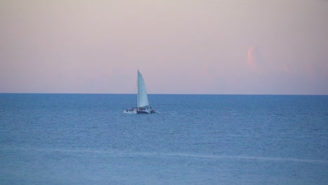 boat sailing across open ocean at sunset