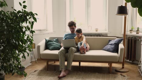 little girl learn to use laptop under control of father