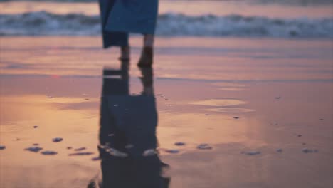 Mujer-Joven-En-Pantalones-Azules-Caminando-Sola-En-La-Playa-Al-Atardecer