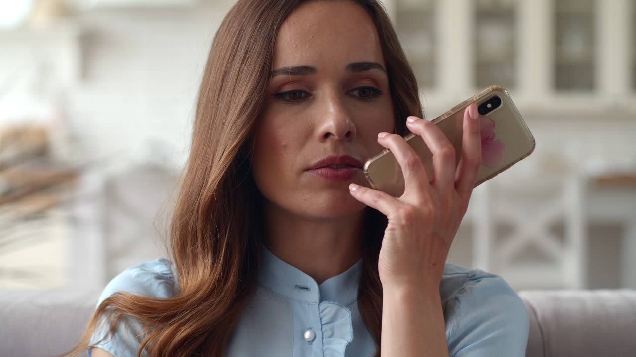 Portrait of focused business woman making phone call in living room.