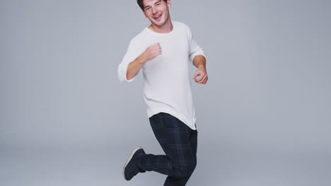 Foto-De-Estudio-De-Gran-Angular-De-Un-Joven-De-Fondo-Blanco-Bailando-En-Cámara-Lenta