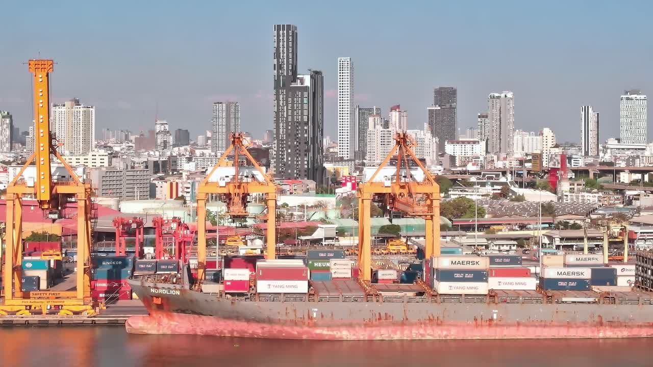 Cargo ships and containers in Bangkok port with city skyline background