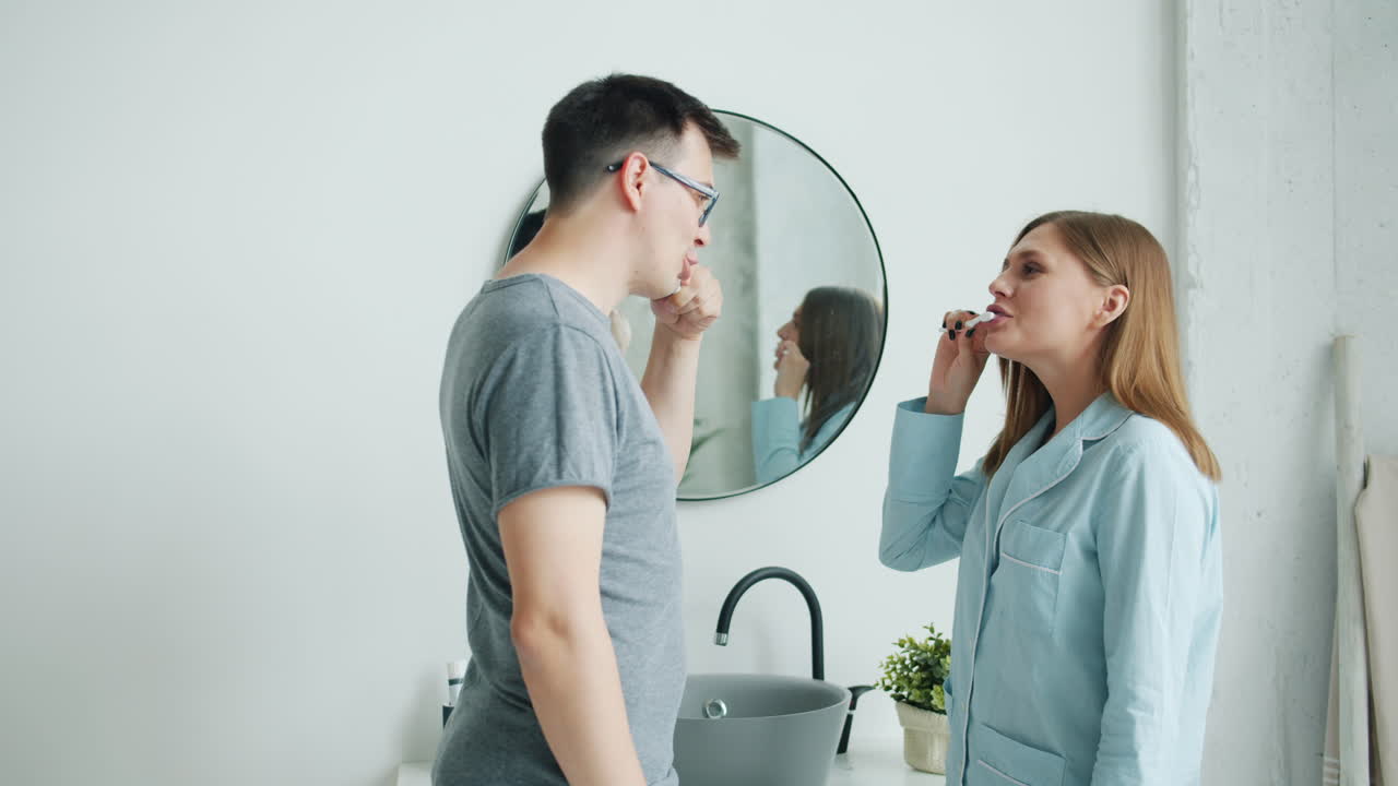 Couple Brushing Teeth Together in Bathroom