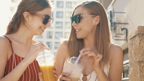 two friends enjoying smoothies outdoors