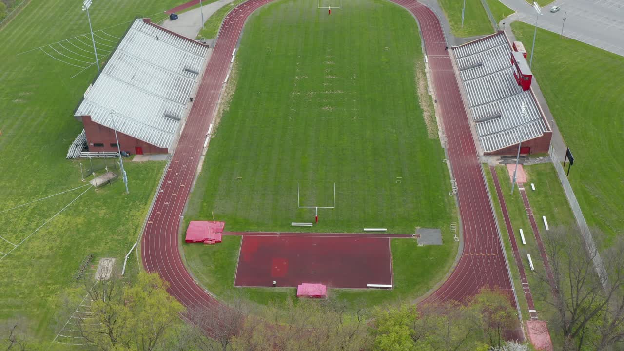 Un'inclinazione aerea verso l'alto rivela una pista e un campo di atletica leggera