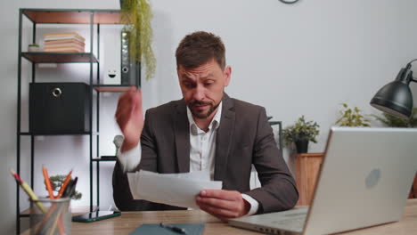 Stressed-businessman-looking-at-unpaid-bank-debt-loan,-throws-paper-document-bills,-financial-crisis