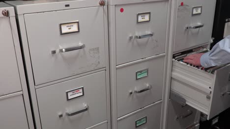 office temp worker looking through file cabinets for a file folder