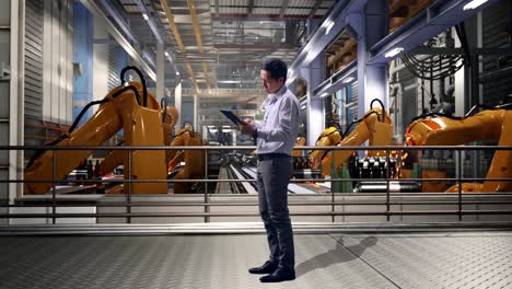 full body side view of an asian male professional worker standing with his tablet with industrial robotic arms working, he is nodding his head with dissapionted