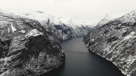 rocky and snow-capped mountains in geirangerfjord norway - aerial shot