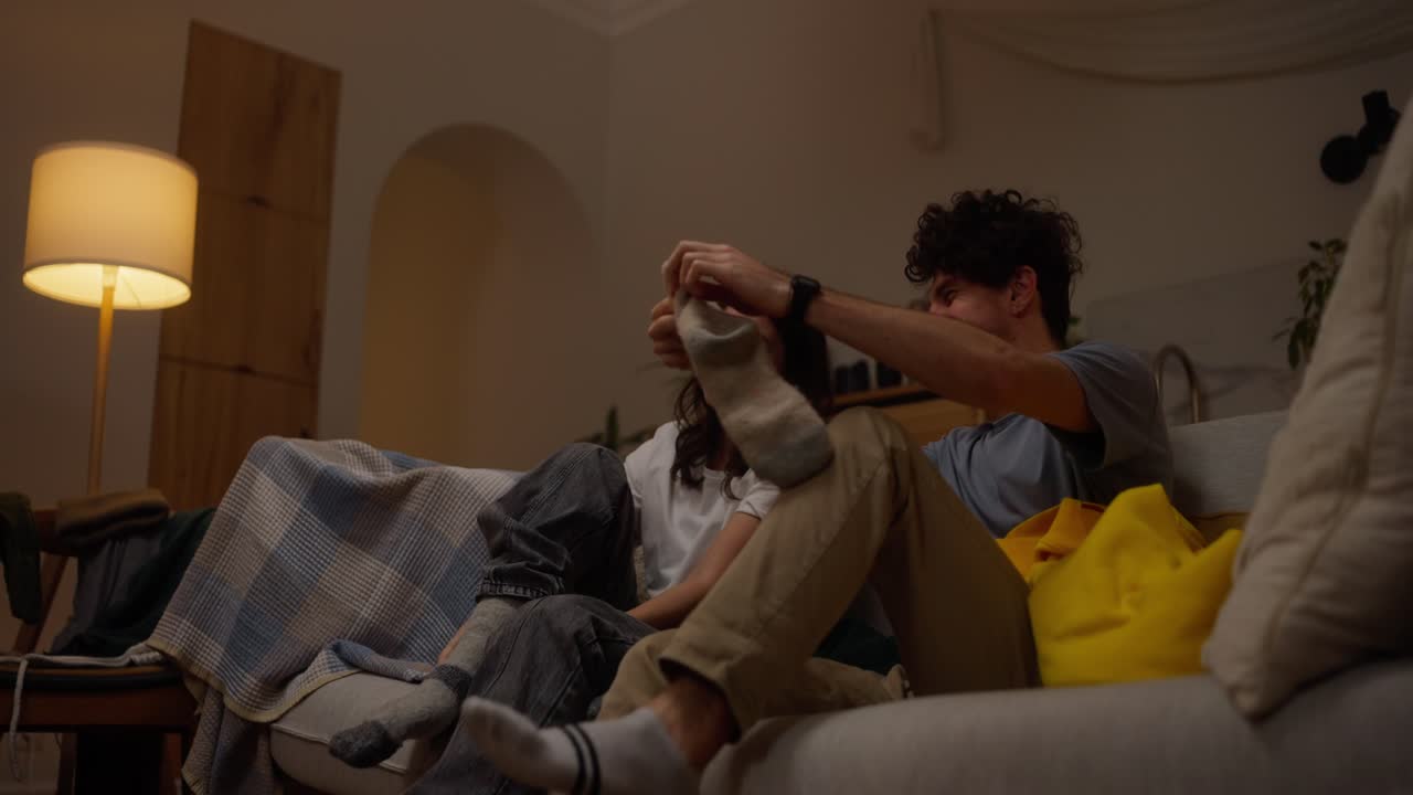 Couple Relaxing on Sofa at Night