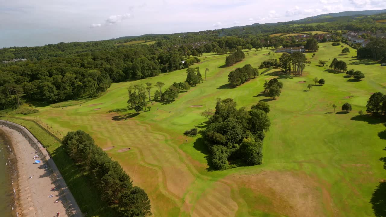 Front-on advancing 4K 60FPS aerial of Helen's Bay Golf Club in County Down, Northern Ireland on a bright summer day. Produced with Rec709 color