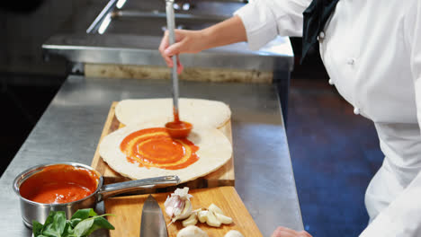 chef aplicando salsa en el pan plano