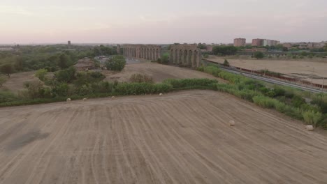 an aerial shot of an italian aqueduct as the drone approaches the structure.