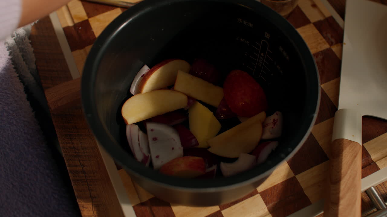 Chopped apples and onions in pot for apple braised chicken recipe