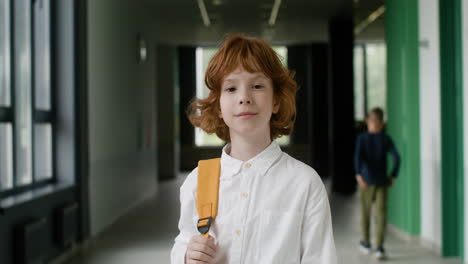 schoolboy looking at camera in school corridor.