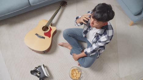 teenager relaxing at home with guitar and vr headset