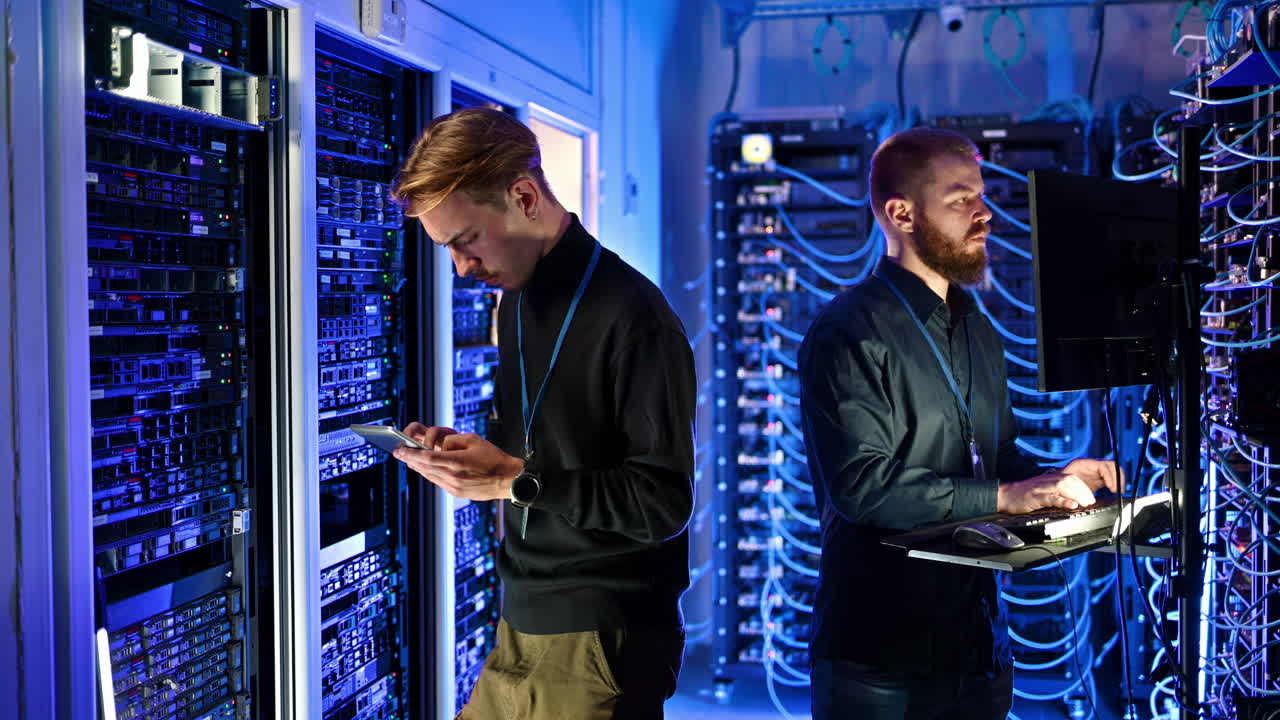 Two men programming in a server room