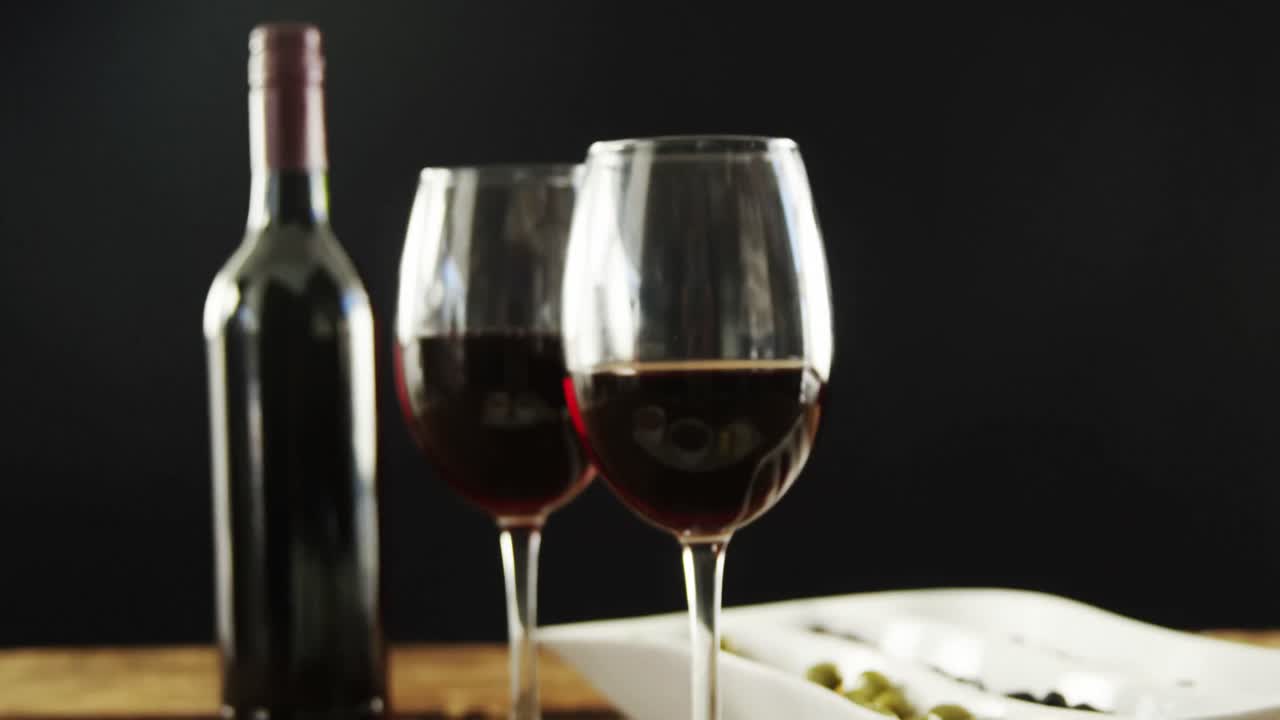 Olive, arachidi e formaggio serviti con vino rosso